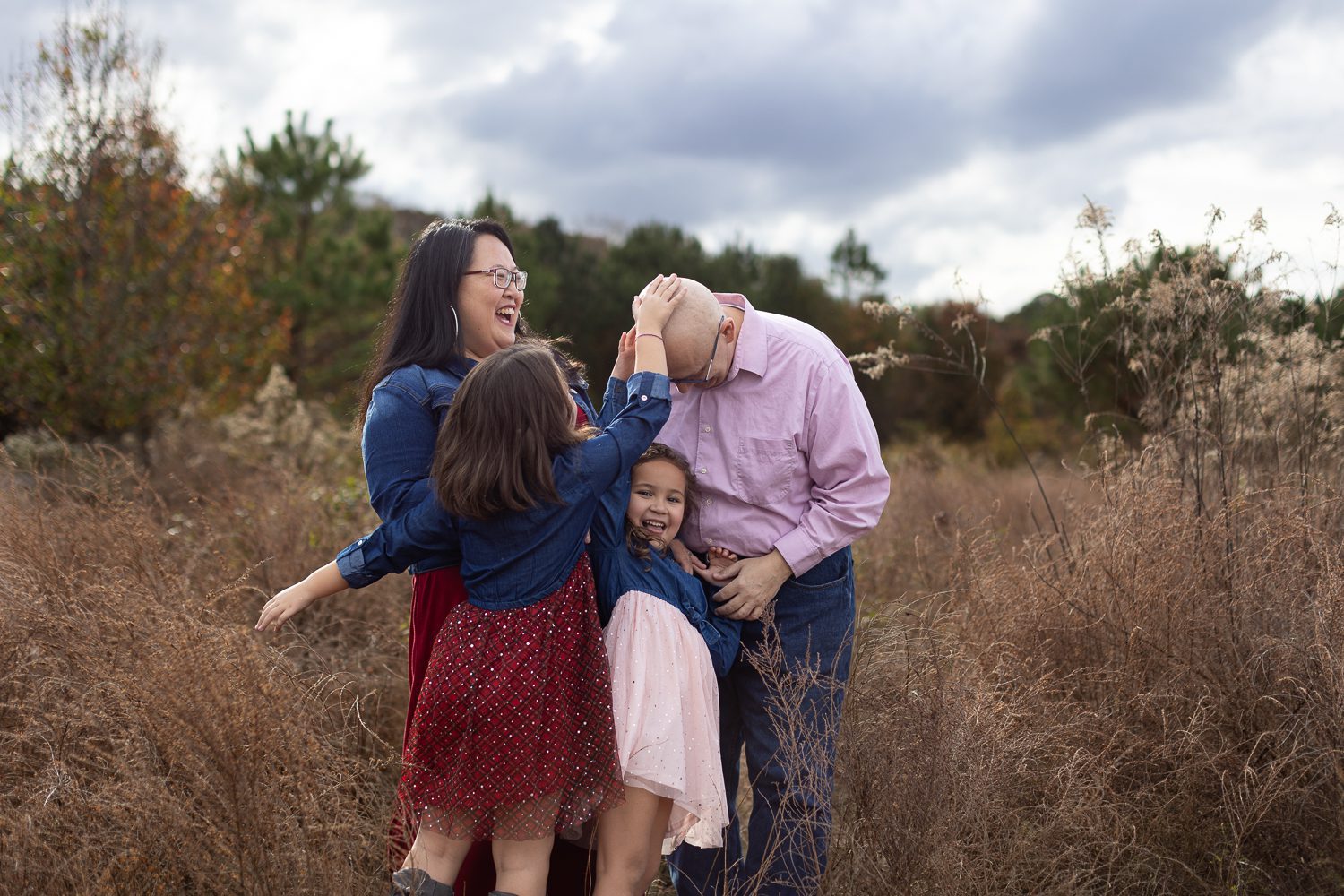 family laughing in field at Garrard Landing Park in Alpharetta