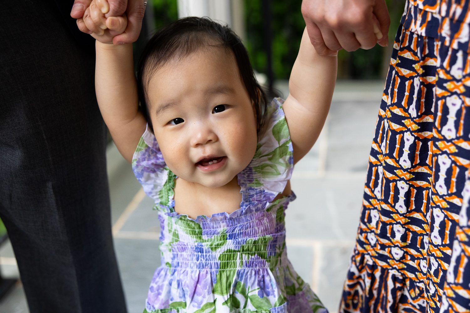 One year old baby girl holding hands while standing