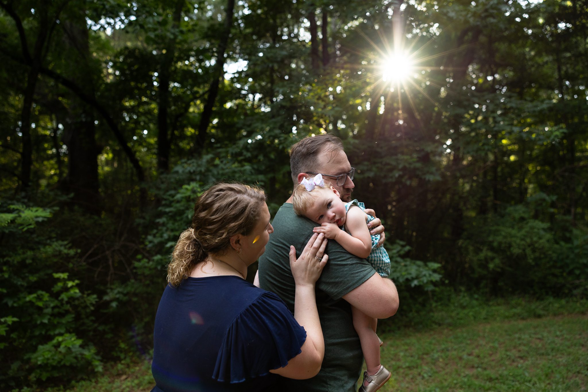 Parents cuddling baby girl in golden light during Marietta family session