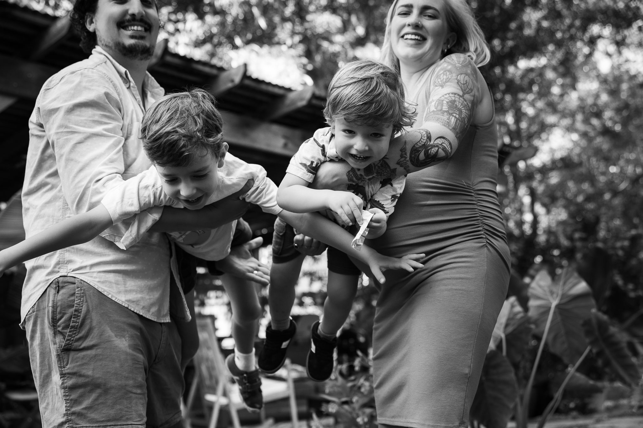 Black and white family maternity photo with parents and two sons