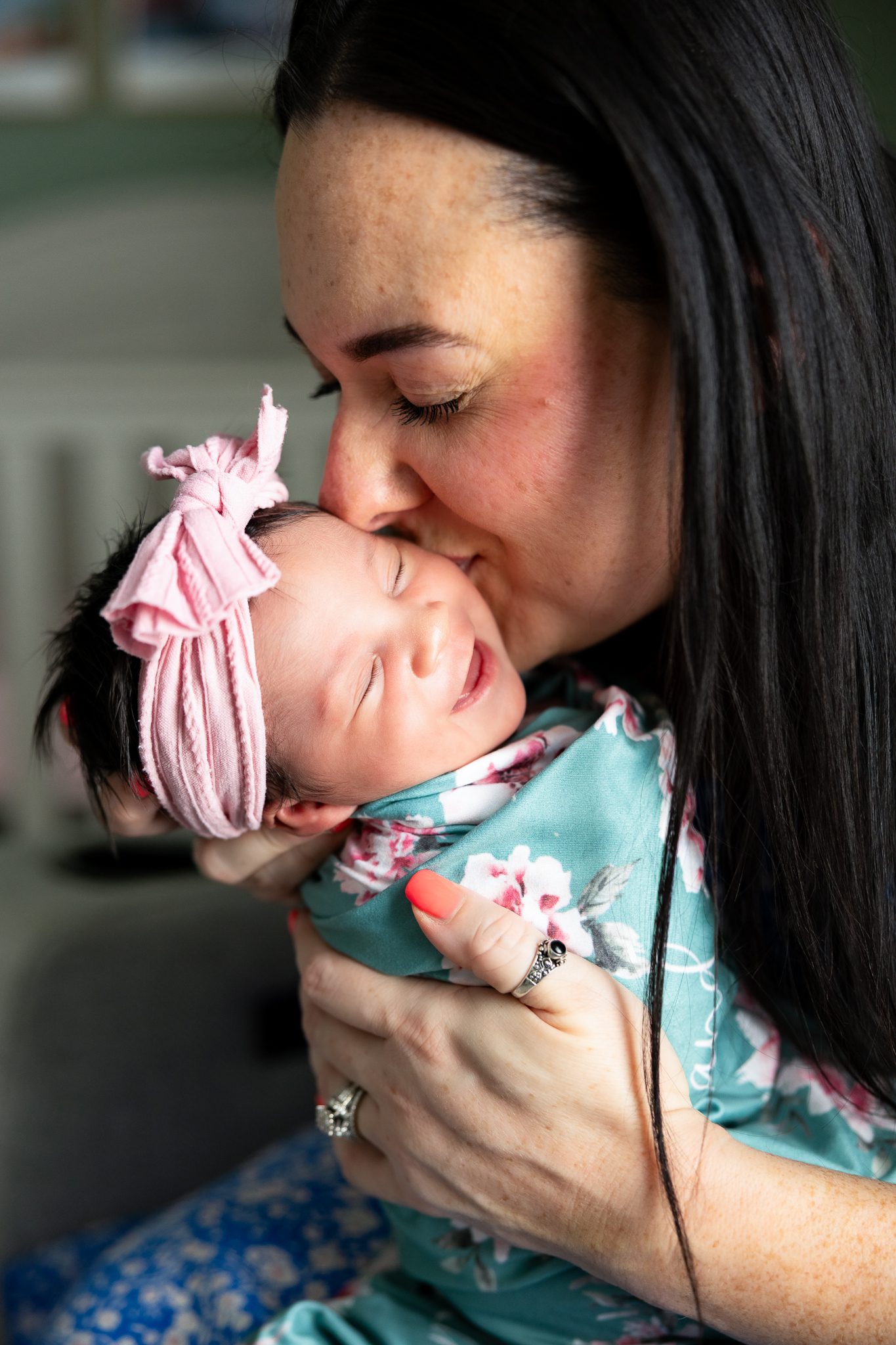 Mom kissing newborn baby girl during in-home newborn session