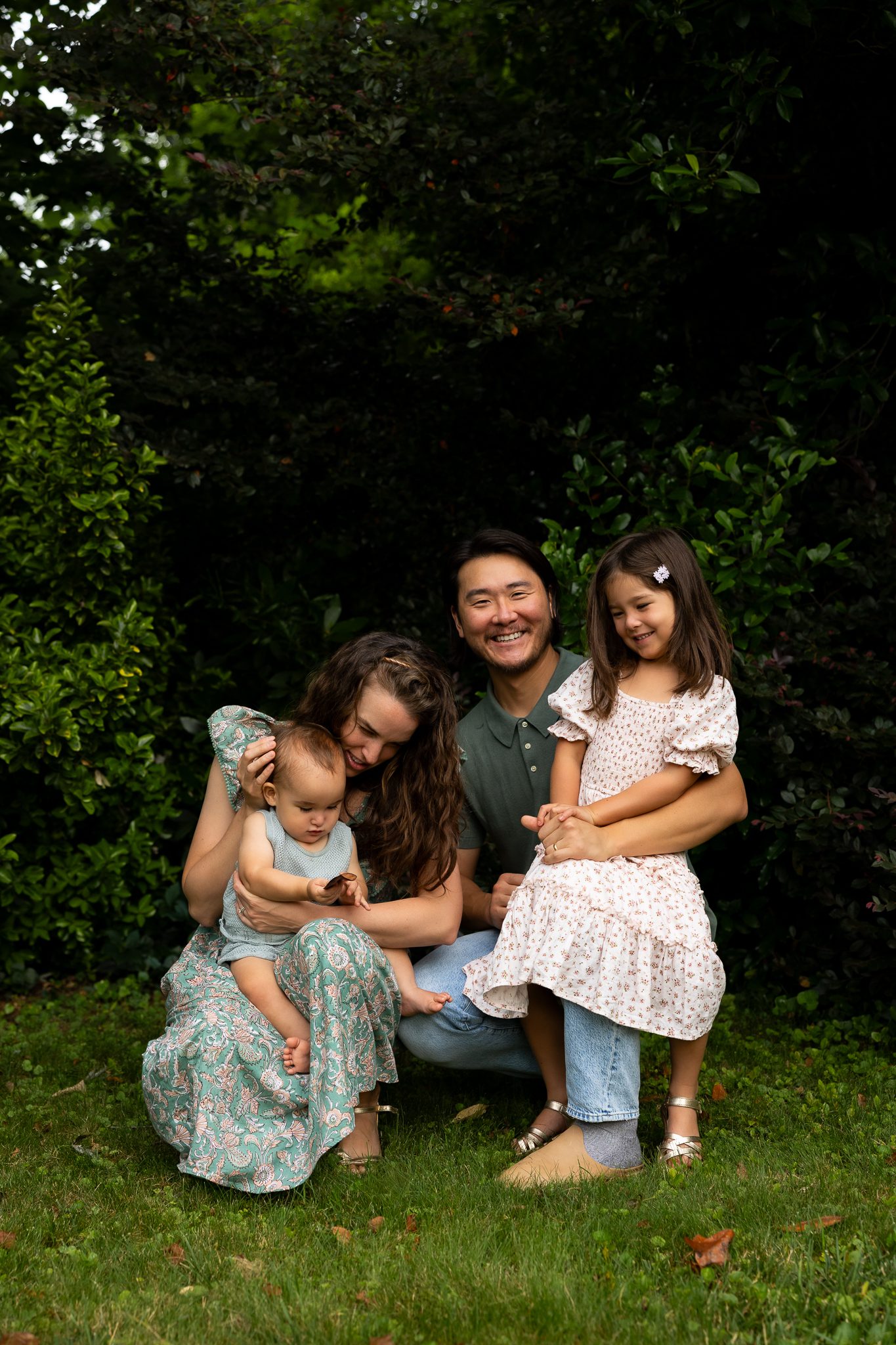 Family of four sitting under trees during Smyrna family session